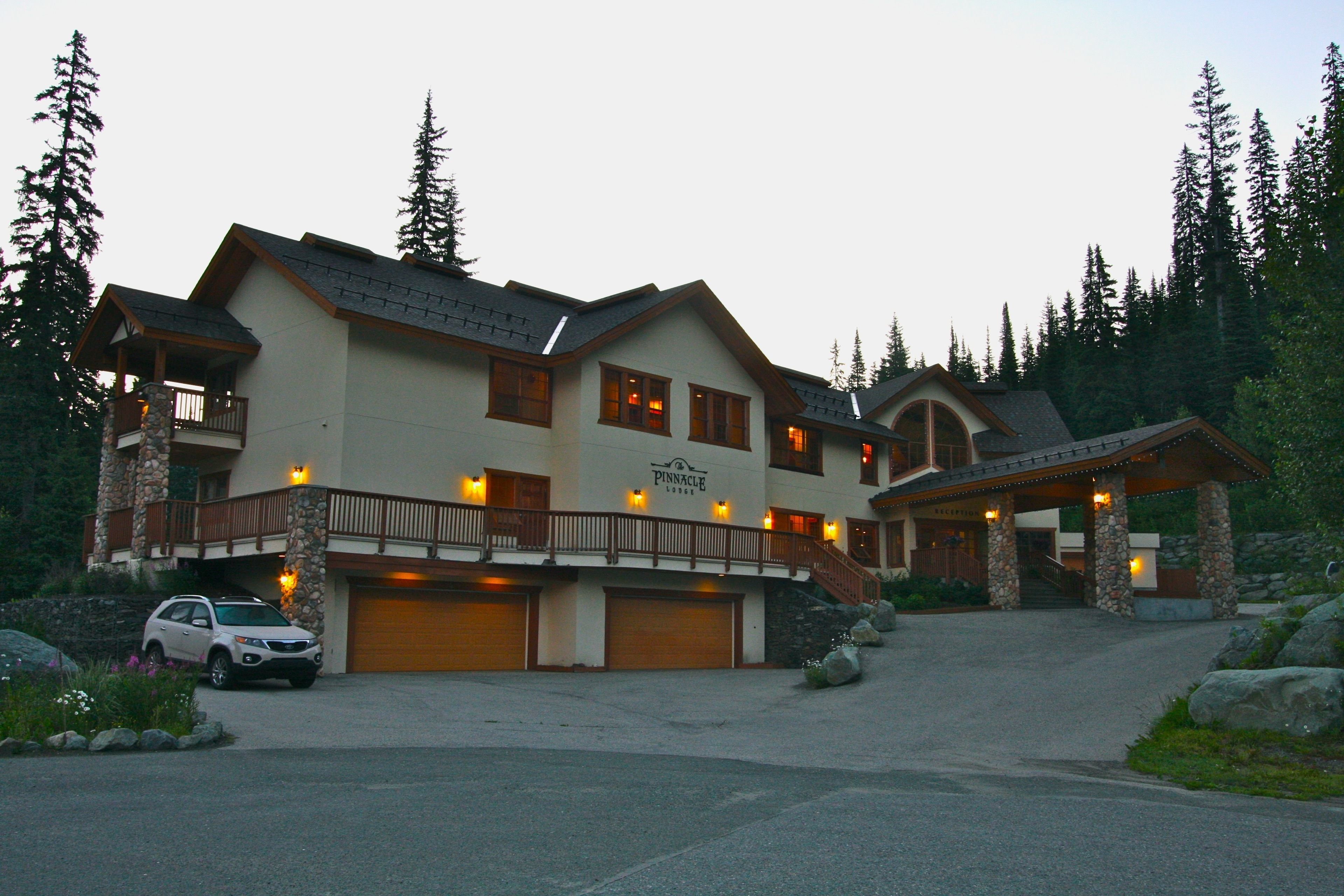 A large, multi-story lodge with a stone facade, multiple garages, and a covered entrance.
