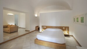 A modern bedroom with a large bed, a sofa, and a mirror. - Santacroce Luxury Rooms (Lecce)