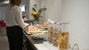 Zona de bufé con diversas opciones de comida y una persona atendiendo.