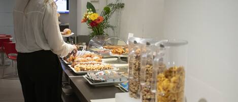 Un espace buffet proposant divers plats et une personne qui sert les clients.