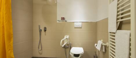 A small, modern bathroom with a shower, toilet, and towel rack.