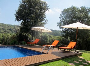 Una piscina al aire libre, sombrillas, tumbonas