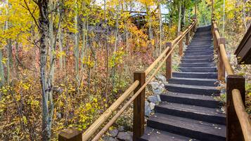 A wooden staircase surrounded by trees with autumn foliage.