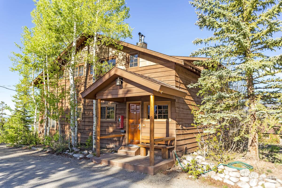 Une cabane rustique avec une façade en bois, une véranda et une cheminée.