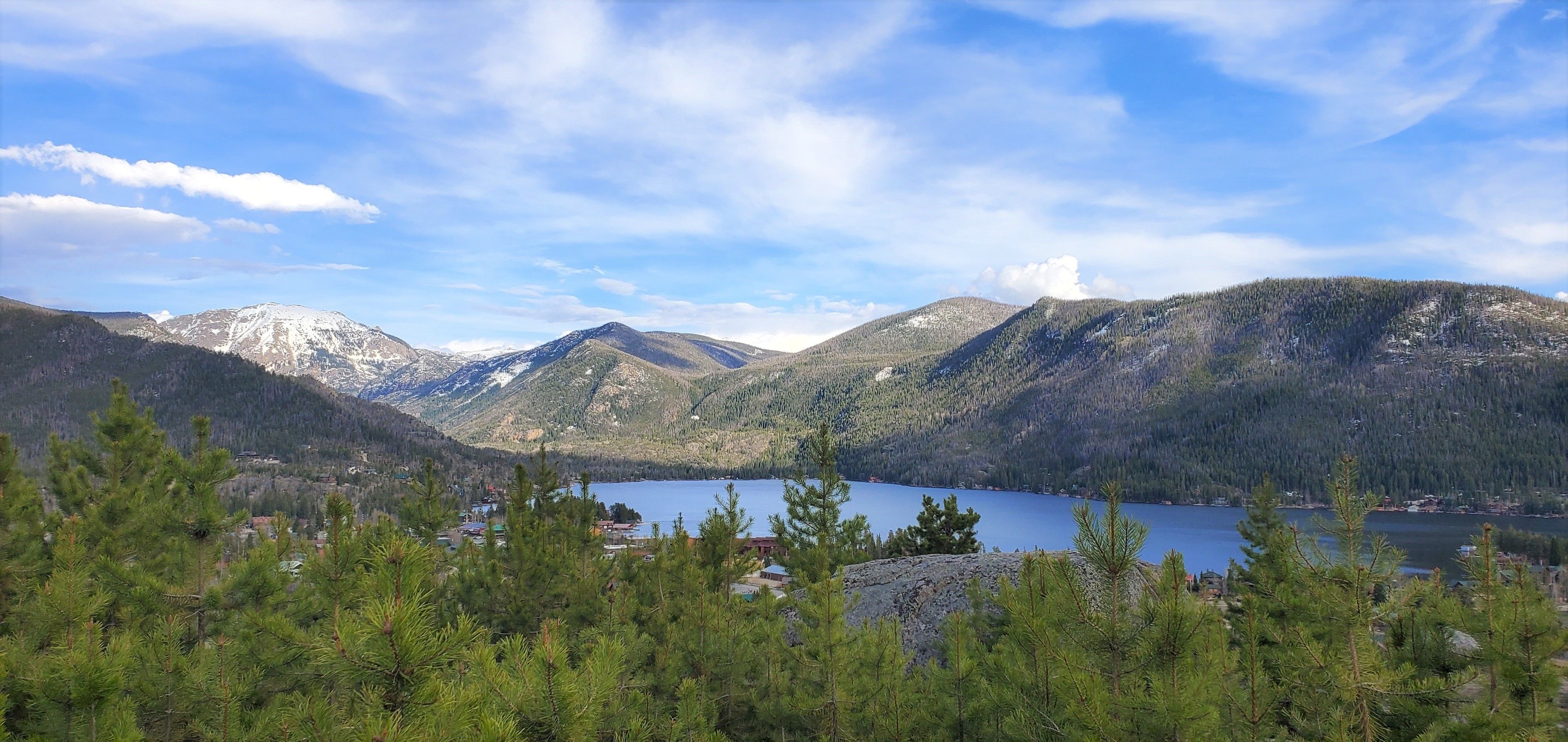 Un paysage montagneux avec un lac et un petit village au premier plan.