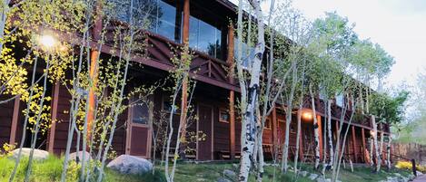 A wooden lodge with large windows and a stone pathway.