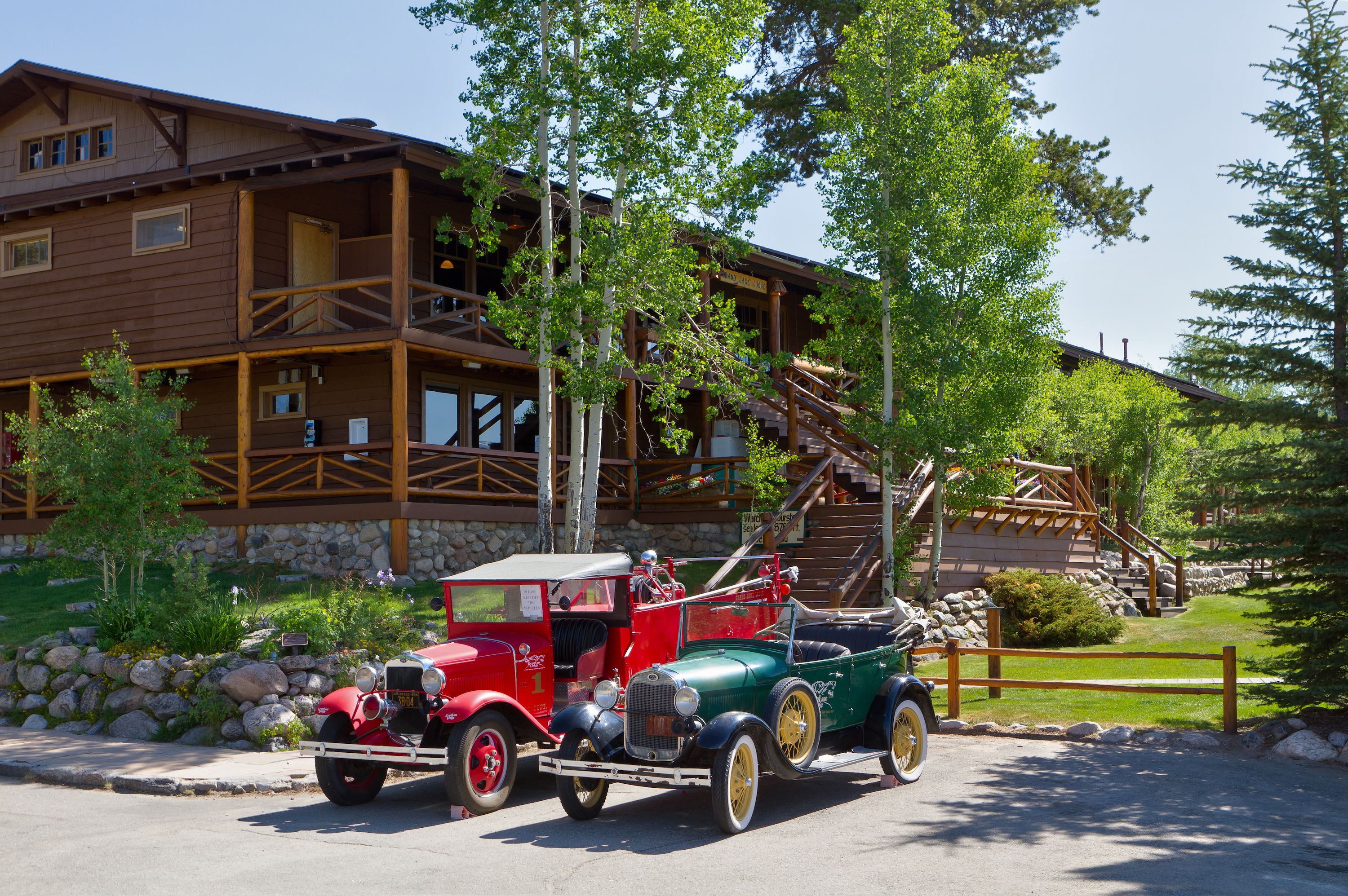 A rustic lodge with a stone facade, wooden balconies, and a staircase leading to an upper level.