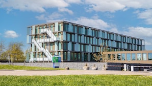 A modern hotel with a multi-story structure, large windows, and a visible staircase. - Holiday Inn Express Utrecht - Papendorp by IHG (Utrecht)
