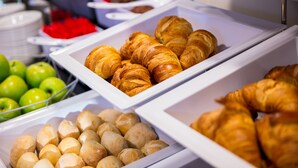 A buffet with various food items including pastries and fruits.