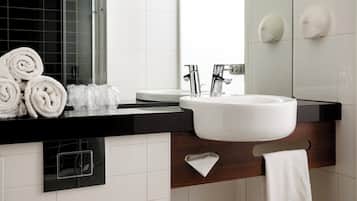 A modern bathroom with a white sink, black countertop, and a mirror.