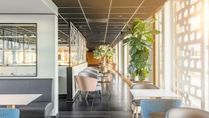 A modern interior with a long corridor, seating areas, and large windows. - Holiday Inn Express Utrecht - Papendorp by IHG (Utrecht)