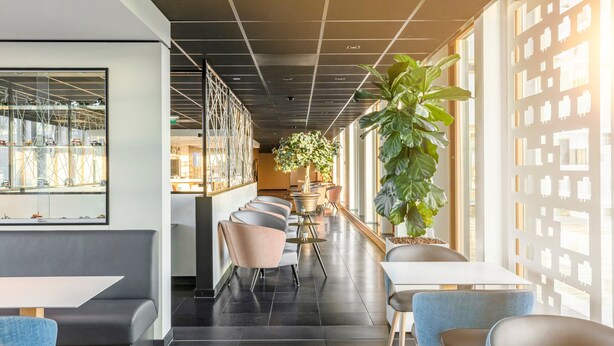 A modern interior with a long corridor, seating areas, and large windows. - Holiday Inn Express Utrecht - Papendorp by IHG (Utrecht)