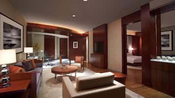 Una habitación de hotel moderna con sala de estar, dormitorio independiente, comedor y baño.