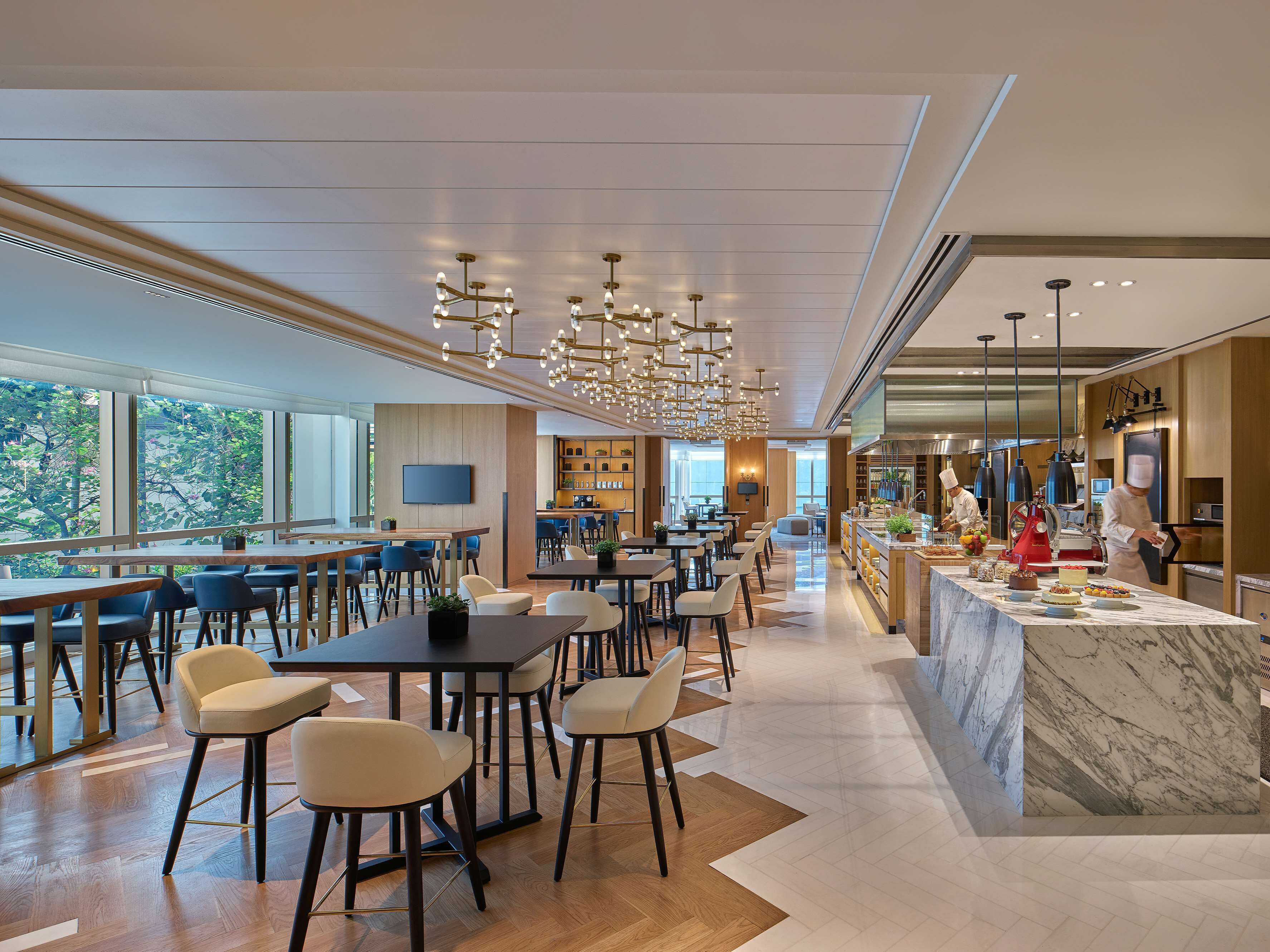 En moderne restaurant med bar, siddepladser og et synligt køkken.