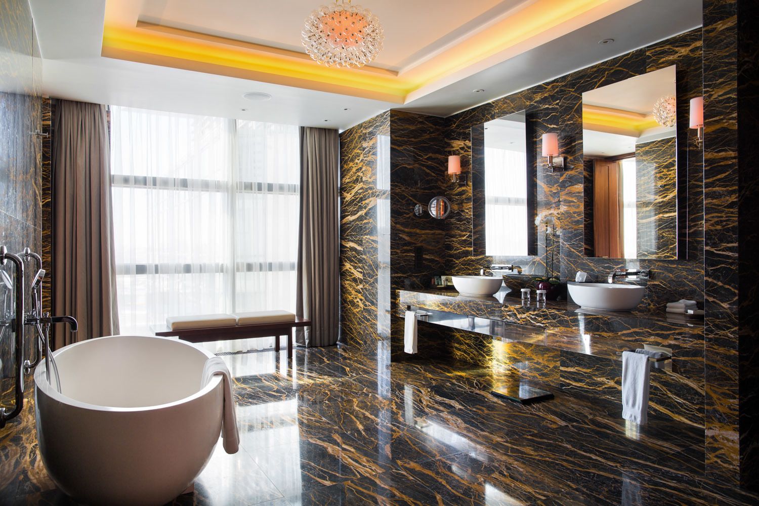 A luxurious bathroom with a large bathtub, two sinks, and a vanity area.