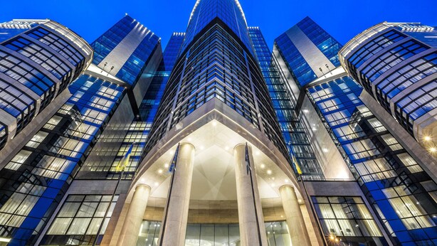 A modern high-rise building with a distinctive curved glass facade and a central entrance with columns. - Hilton Kyiv (Kyiv)