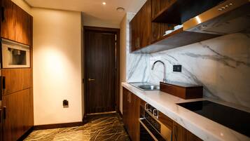Una cocina moderna con armarios de madera, salpicadero de mármol y electrodomésticos de acero inoxidable.