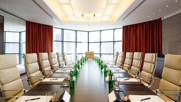 A conference room with a long table, chairs, and green bottles.