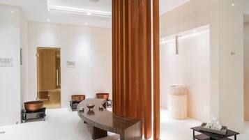 Un intérieur moderne avec un comptoir d’accueil en bois, un grand miroir et un design minimaliste.