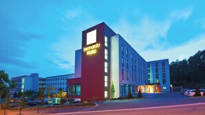 A modern hotel building with a prominent 'Leonardo Hotel' sign, multiple floors, and a parking lot. - Leonardo Hotel Völklingen - Saarbrücken (Voelklingen)
