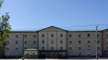 A MainStay Suites hotel with a symmetrical facade, multiple windows, and a central entrance.