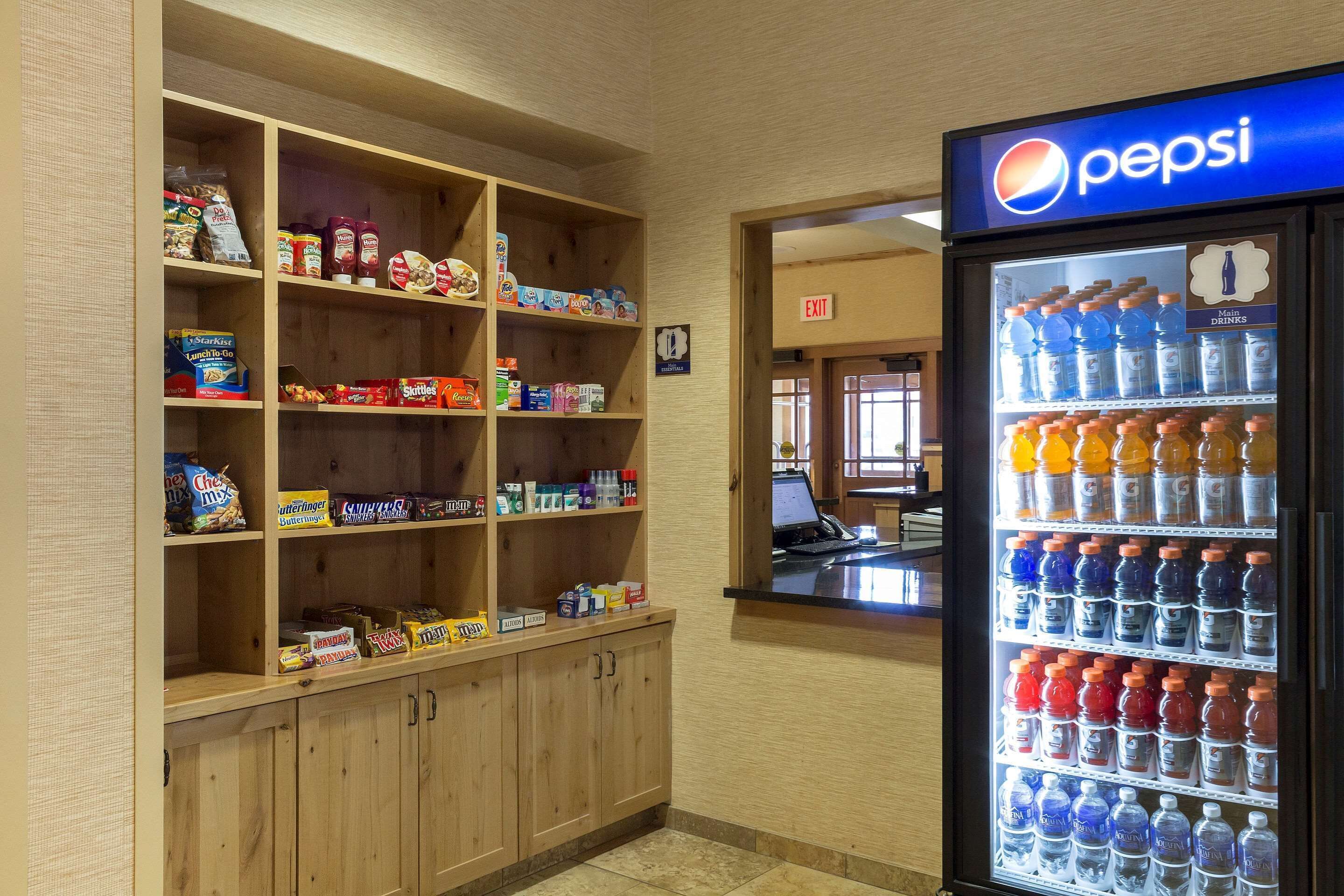 Máquina de vendas abastecida com bebidas Pepsi e uma prateleira com diversos snacks.