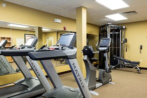 A gym with treadmills, a weight machine, and a mirror. - MainStay Suites Williston (Williston)