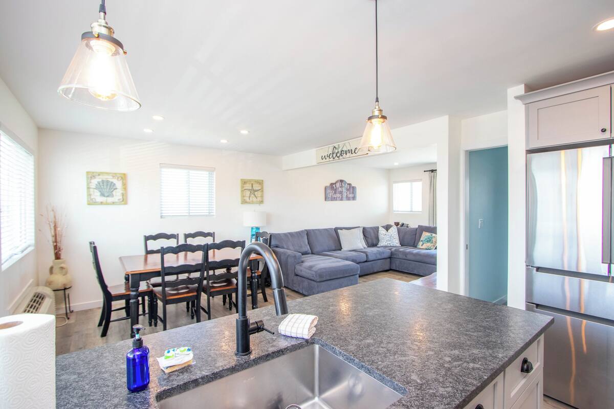 A modern kitchen with a built-in island, stainless steel appliances, and pendant lighting.