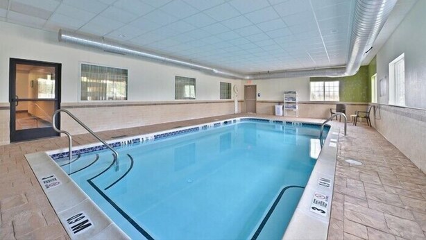 Una piscina interior con carriles claramente marcados, suelo de baldosas y techo con diseño de cuadrícula.