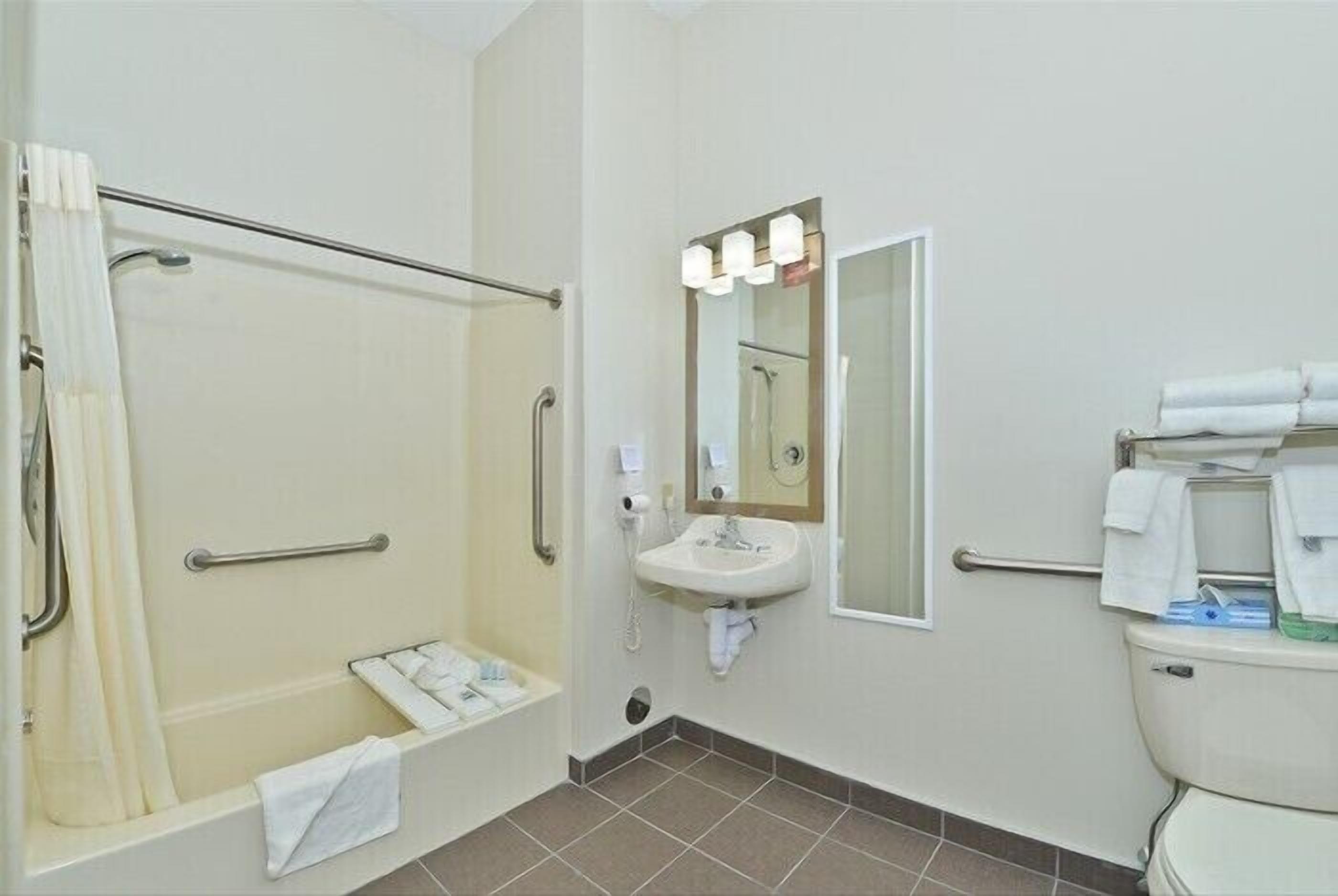 Een badkamer met een douche, wastafel en toilet.