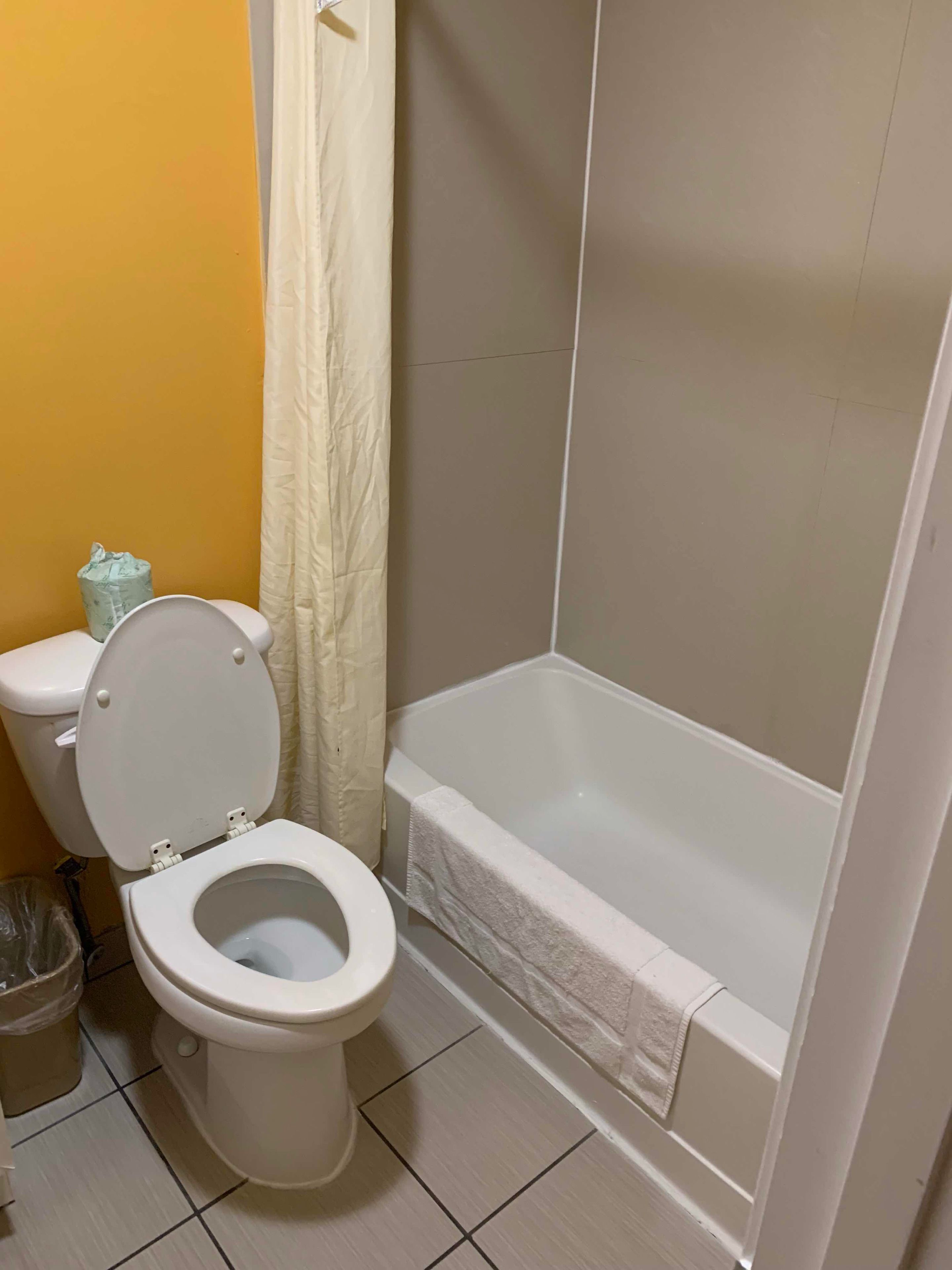 Un baño con inodoro, bañera y cortina de ducha.