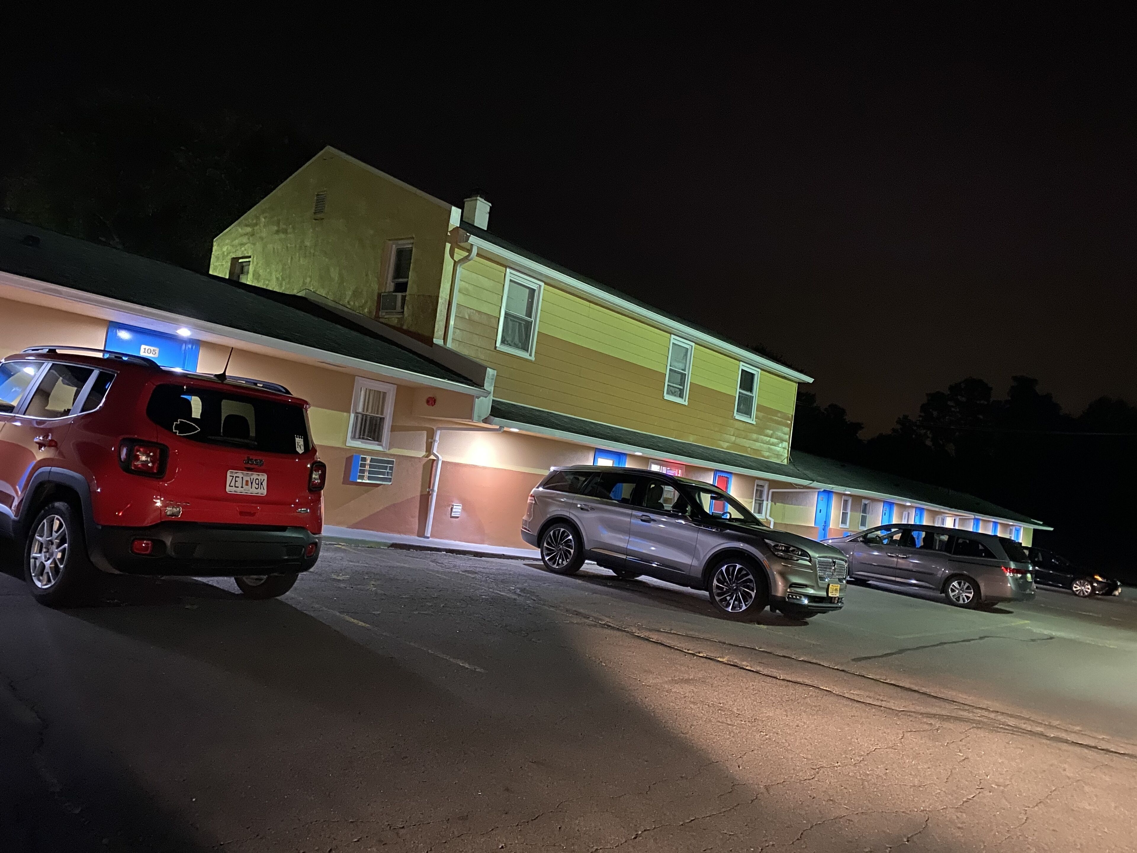Un immeuble devant lequel sont garées plusieurs voitures.