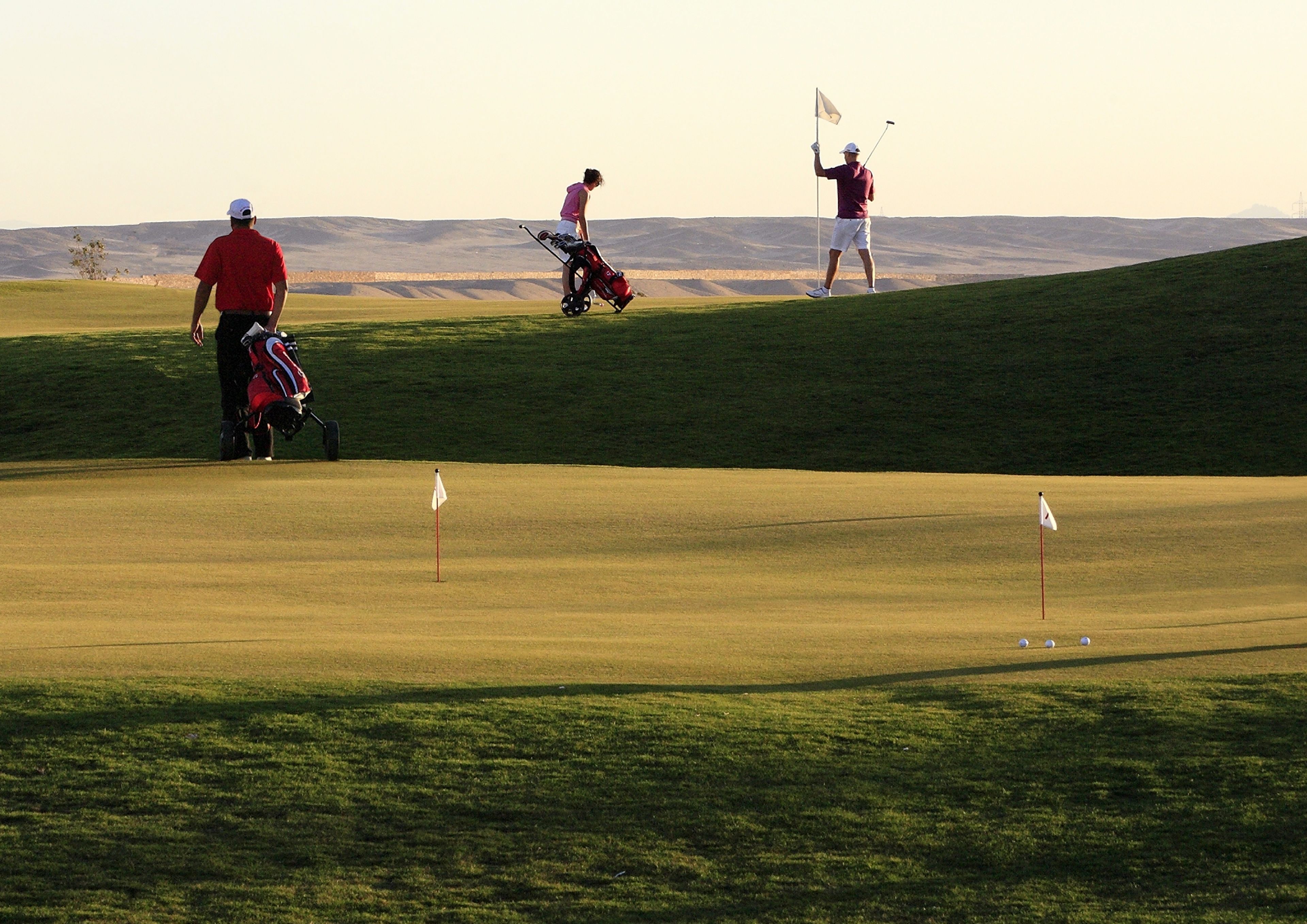 Ein Golfplatz mit Spielern und einer Golftasche.