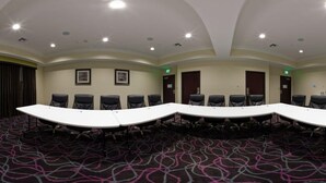 A conference room with a long table, multiple chairs, and framed pictures on the walls. - Holiday Inn Express Hotel & Suites Raceland - Highway 90 by IHG (Raceland)