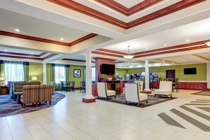 A spacious lobby with a reception desk, seating area, and a large window with curtains. - Holiday Inn Express Hotel & Suites Raceland - Highway 90 by IHG (Raceland)