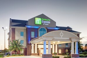 A Holiday Inn Express & Suites building with a brick facade, large windows, and a covered entrance area. - Holiday Inn Express Hotel & Suites Raceland - Highway 90 by IHG (Raceland)