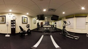 A gym with treadmills, stationary bikes, and a weight machine.