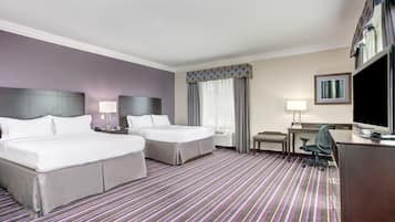 Une chambre d’hôtel avec deux lits, un bureau, une chaise, une télévision et une fenêtre avec des rideaux.