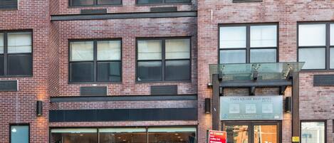 A multi-story hotel with a brick facade, large windows, and a glass entrance.