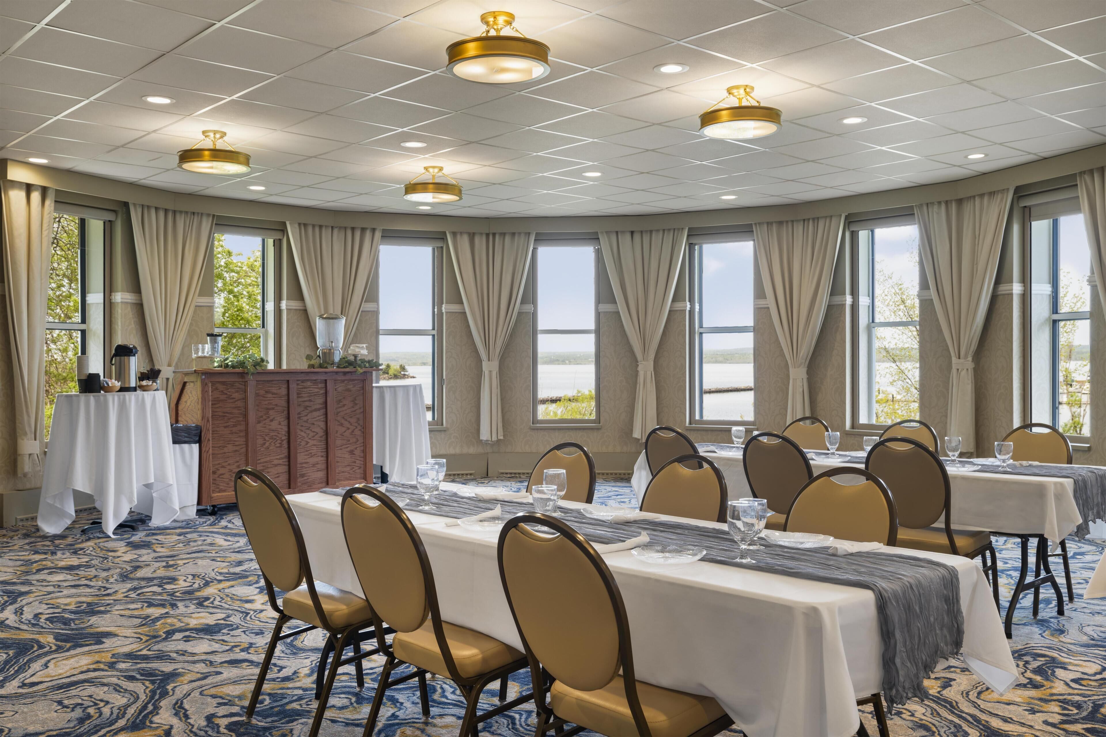 A conference room with tables, chairs, and a podium.