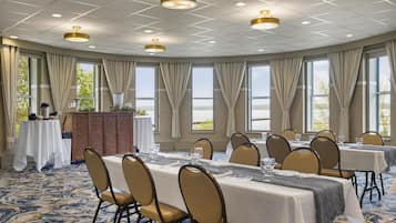 A conference room with tables, chairs, and a podium.