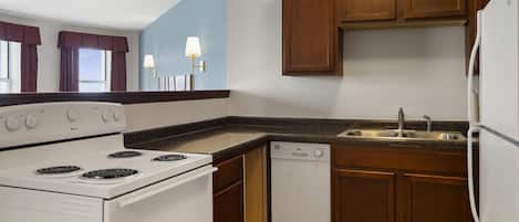A kitchen with a stove, dishwasher, and cabinets.