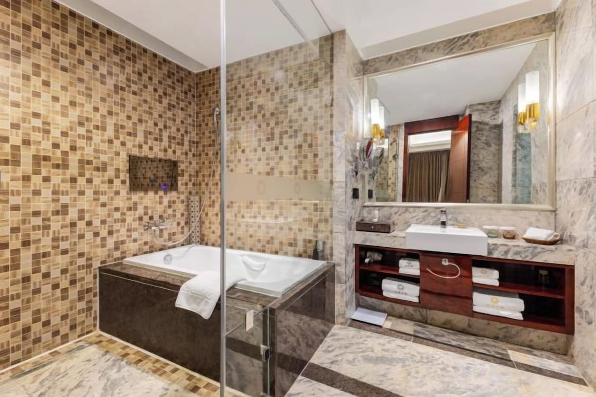A modern bathroom with a glass-enclosed shower, a freestanding bathtub, and a vanity with a mirror and sink.