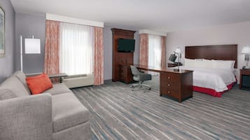 Een hotelkamer met een groot bed, een bureau, een bank en een televisie.
