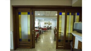 A hallway with tables and chairs, leading to a dining area. - Hotel Vazzana (Volpiano)