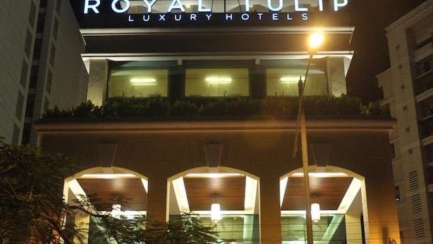 Un edificio con un letrero que dice "ROYAL TULIP LUXURY HOTELS" durante la noche.