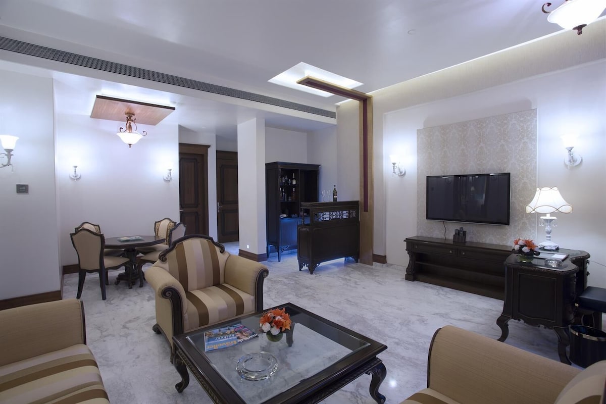 A spacious living room with a dining area, a TV, and a bar.