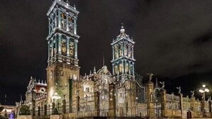 A historic building with two prominent towers, a courtyard, and a reflective water surface. - Hotel de Talavera (Puebla)