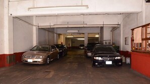 A parking garage with multiple cars parked in rows. - Hotel De Talavera (Puebla)