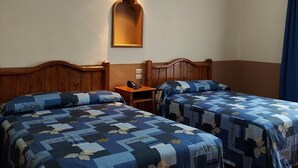 A hotel room with two beds, wooden headboards, a nightstand with a phone, a wall-mounted light fixture, and a mirror. - Hotel De Talavera (Puebla)